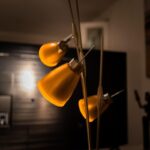 Lampadaire arc avec trois abat-jours jaunes illuminant un salon sans plafonnier