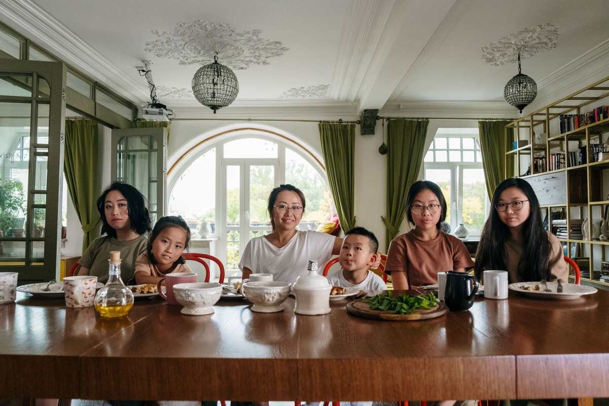 Famille asiatique assise autour d'une table en bois, en train de dîner