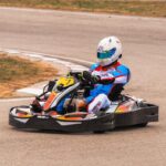 un pilote en kart dérapant sur virage de circuit