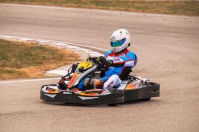 un pilote en kart dérapant sur virage de circuit
